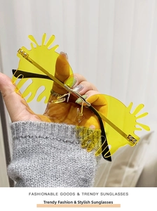 Close-up of yellow flame-shaped rimless sunglasses with gold metal temples and pads