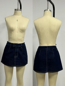 Vista dettagliata fronte e retro di una minigonna di jeans blu scuro su un manichino