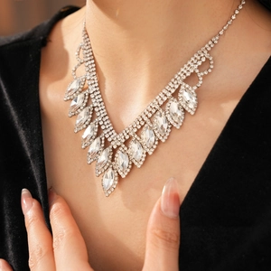 Macro shot of a luxury V-shaped silver necklace with marquise and round crystals on a model