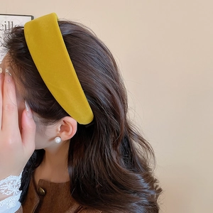 Detail of mustard yellow velvet wide headband worn by model for an elegant winter look
