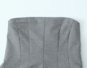 Gros plan du haut bustier gris montrant les coutures verticales et la texture du tissu