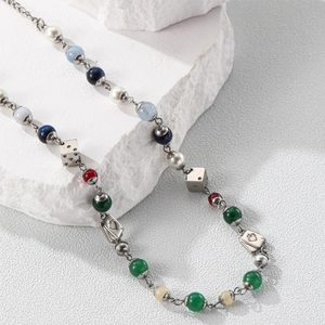Detailed macro of vintage dice beads and poker charms on a colorful beaded necklace