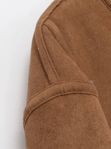 Détail macro des coutures et de la texture d'une veste tendance en daim marron