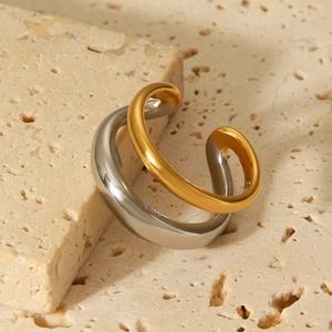 Detail of two-tone gold and silver double-layer ring on a natural travertine stone base