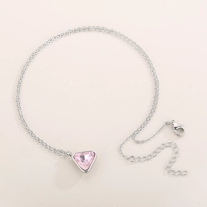 Detail view of a silver-tone necklace with a triangular pink crystal pendant and lobster clasp