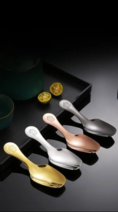 Detail of four stainless steel tea scoops with crown handles in gold silver and rose gold
