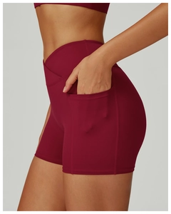Close-up of high-waist yoga shorts in deep red with side pockets and V-cross waistband