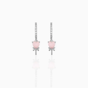 Close-up of heart-shaped pink zircon earrings with 18k gold plating and bow detail