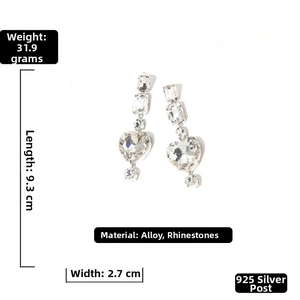 Macro detail of long tassel heart earrings with sparkling rhinestones and 925 silver pins