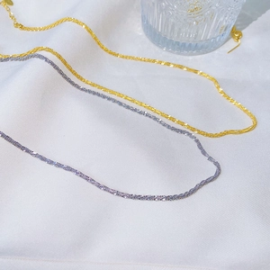 Detail of delicate gold and silver stainless steel chains with shimmering texture
