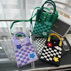 Détail de la texture en maille des mini sacs pour téléphone en vert, violet et noir à fleurs