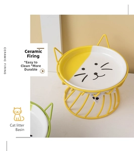 Detailed view of yellow elevated ceramic cat bowl with cute face print and ear-shaped metal stand