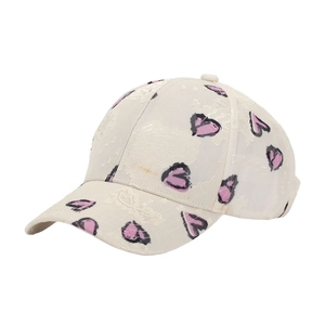 Close-up of cream baseball cap with pink heart print and textured jacquard fabric detail