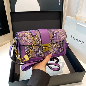 Vintage purple snakeskin shoulder bag with gold chain and metal buckle in studio display