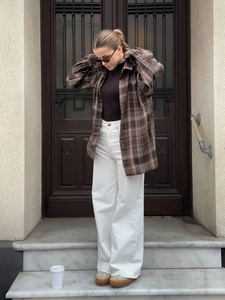 Women's brown plaid long sleeve shirt with white high-waist wide-leg pants and undershirt