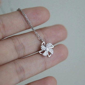 Macro shot of a rotating silver windmill pendant with pavé set white cubic zirconia crystals