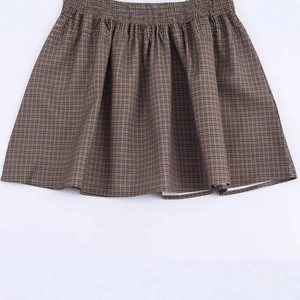 Women's brown plaid mini skirt with elastic high waist and classic checkered pattern