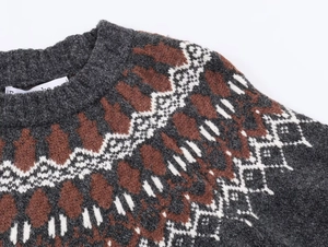Detail of grey crewneck knit sweater featuring red and white Fair Isle jacquard patterns
