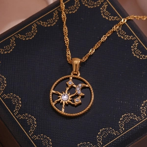 Detail of 18K gold-plated necklace with sun and moon pendant on jewelry box