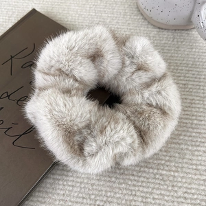 Close-up of soft faux mink fur scrunchie in light brown for autumn and winter hair styles