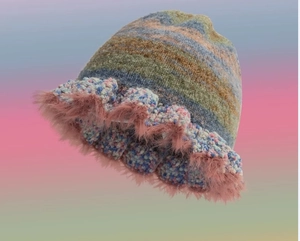 Close-up of multicolored knit bucket hat featuring pink faux fur trim and textured yarn