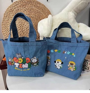 Detailed embroidery on blue denim tote bags with cute cartoon patterns and top handles