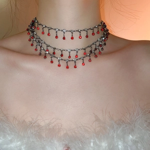 Detail of layered red rhinestone choker with tassel pendants on model for elegant styling