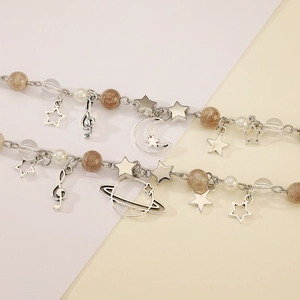Detailed view of silver charm bracelets featuring hollow stars, moon and Saturn pendants