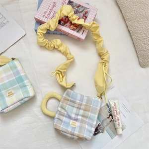 Detail of checkered portable water bottle bag with ruffled strap and circular handle
