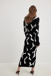 Back view of a slim-fit knit maxi dress featuring black and white abstract jacquard patterns