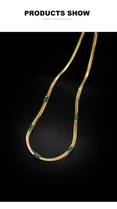 Dettaglio collana a catena serpente dorata con quattro zirconi verdi taglio smeraldo