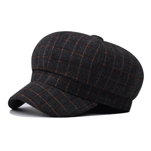 Detail of grey wool plaid newsboy cap with textured tweed fabric and button top
