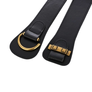 Detailed macro view of black elastic corset belt featuring retro gold metal hardware buckle