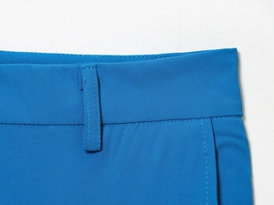 Détail de la taille du pantalon bleu avec passants de ceinture et coutures précises