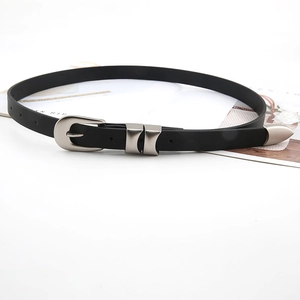 Minimalist black leather belt with silver matte pin buckle and metal tip on magazine