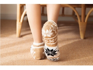 Detailed knit texture of winter socks with classic camel and white snowflake patterns