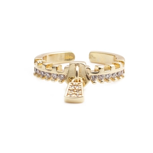 Detailed view of golden zipper-shaped ring with pavé zircons and a lock charm