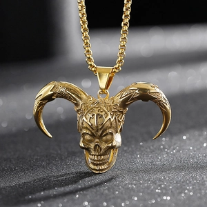 Macro shot of a golden horned skull pendant with a box chain on a dark bokeh background
