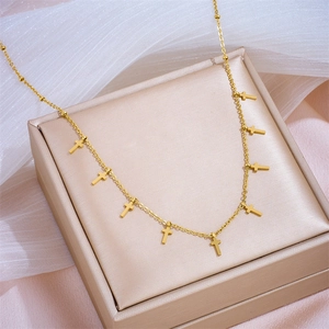 Gold stainless steel necklace with cross tassels on a luxury jewelry gift box