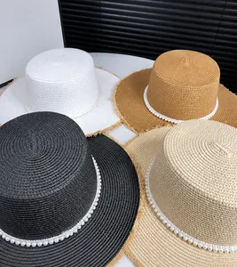 Detail view of four straw hats with elegant pearl straps and fringe brim in multiple colors
