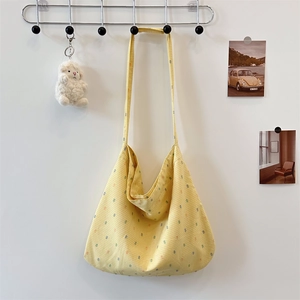 Detail of yellow checkered floral tote bag hanging on wall with a soft cloth texture