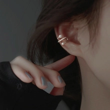 Macro detail of gold layered ear cuff with white pearls and sparkling pavé crystals