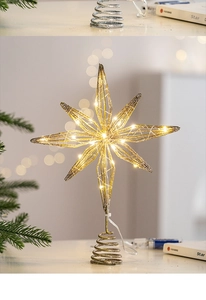 Close-up of golden glitter star tree topper with warm white LED lights and spring base