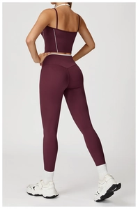 Detailansicht des weinroten Yoga-Sets mit weißen Kreuzgurten und High-Waist-Leggings