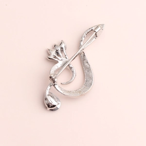 Detailed back view of silver musical note brooch showing the secure pin closure and texture