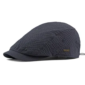 Waterproof breathable seersucker flat cap in dark blue with metal logo and adjustable cord