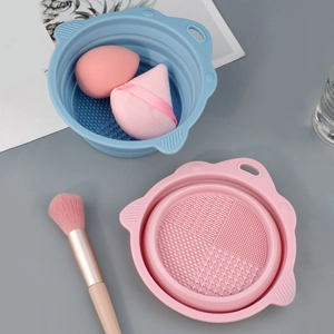 Foldable silicone makeup brush cleaning bowls in blue and pink with various textures