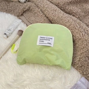 Close-up of a lime green waterproof travel cosmetic bag with a zipper and fabric label