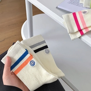Close-up of cotton crew socks with double stripes and cute smiley face embroidery detail