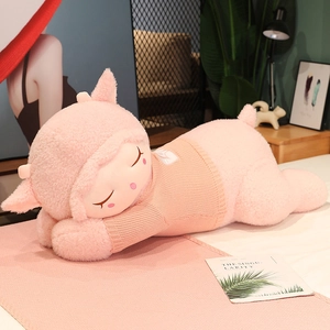 Detail of pink plush lamb pillow made of soft lamb wool with a cozy knitted sweater